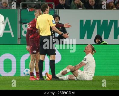 Augsburg, Deutschland. Februar 2025. Marius Wolf (FC Augsburg #11) sitzt verletzt am Boden, Schiedsrichter Sascha Stegemann, David Raum (RB Leipzig); FC Augsburg vs. RB Leipzig, 22. SPIELTAG; DFL-VORSCHRIFTEN VERBIETEN DIE VERWENDUNG VON FOTOS ALS BILDSEQUENZEN UND/ODER QUASI-VIDEO. Quelle: dpa/Alamy Live News Stockfoto