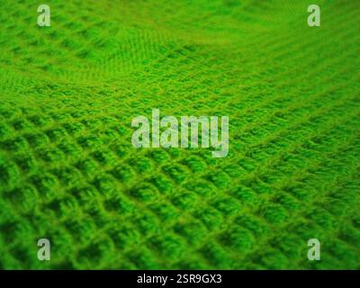 Hintergrund und Textur von grünem Strickgewebe. Hintergrund für die Konstruktion. Das Foto wurde auf einem Mobiltelefon aufgenommen. Stockfoto