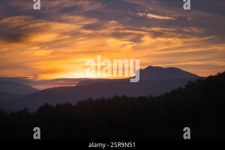 Goldenes Sonnenlicht strahlt ein magisches Leuchten über die Montsec Range und schafft dramatische Silhouetten in der Abenddämmerung, Katalonien Stockfoto