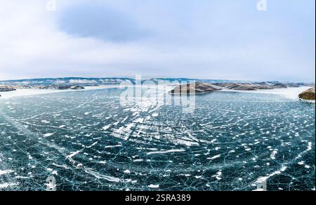 Blick von oben auf den Blue Clear Ice Lake Baikal. Rissüberzug auf gefrorenem Wasser. Kalte Winterlandschaft mit Bergen, sonniger Tag, Natur Stockfoto