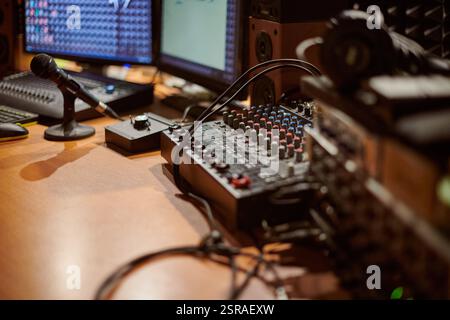 Audio-Mischpult mit Mikrofon in modernem Studio-Setting mit komplizierten Verbindungen und fortschrittlicher Technologie für den Sound Stockfoto