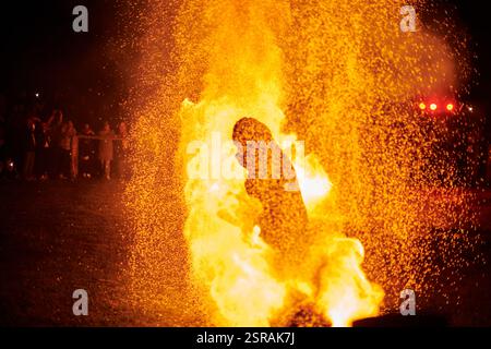 Silhouette zweier Feuerkünstler mit funkelndem Feuerwehrpersonal, das am Nachthimmel ausbricht und die Energie und Kunst der Feuermanipulation während eines Outdours zeigt Stockfoto