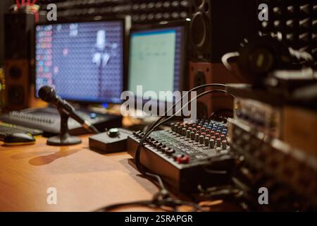 Audio-Mischpult mit Mikrofon in modernem Studio-Setting mit komplizierten Verbindungen und fortschrittlicher Technologie für den Sound Stockfoto