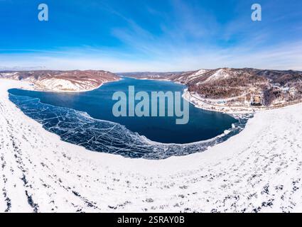 Blick von oben auf den Blue Clear Ice Lake Baikal. Rissüberzug auf gefrorenem Wasser. Kalte Winterlandschaft mit Bergen, sonniger Tag, Natur Stockfoto