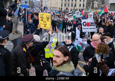 London, Großbritannien. Februar 2025. Eine Frau, die einen Einzelprotest zur Unterstützung von Trump und zur Freilassung von Geiseln führt, die immer noch von der Hamas gehalten werden, hält ein Schild mit der Aufschrift "Trump hat Recht" auf der einen Seite und "Lass mein Volk gehen" auf der anderen Seite, während Tausende während des nationalmarsches für Palästina vorbeiziehen. Die Demonstranten hoben die jüngsten kontroversen Erklärungen des US-Präsidenten hervor, in denen er vorschlug, die Verantwortung für Gaza zu übernehmen und Palästinenser umzusiedeln. Die Frau war nicht bereit, dem Gegenproteste beizutreten und wurde verhaftet, nachdem sie an diesem Tag gegen die Protestbedingungen verstoßen hatte. Stockfoto
