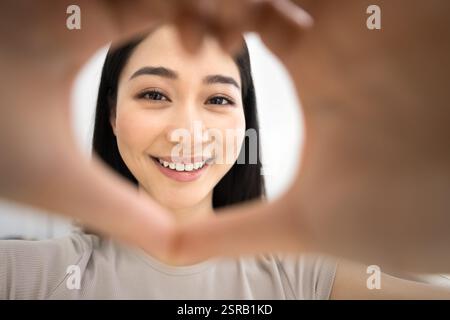Close up face of woman framing camera with hands Stockfoto