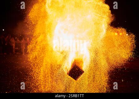 Silhouette zweier Feuerkünstler mit funkelndem Feuerwehrpersonal, das am Nachthimmel ausbricht und die Energie und Kunst der Feuermanipulation während eines Outdours zeigt Stockfoto