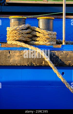 Nahaufnahme von Seilen, die um Schiffspoller gebunden sind, auf einem blauen Boot. Colindres, kantabrien, spanien Stockfoto