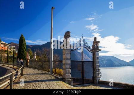 UFER des Lugano-SEES im Vorort Lugano und Blick auf den Luganer See. Verschwommene Bewegung von Menschen in der Ferne. Tor zu einer Villa. Stockfoto