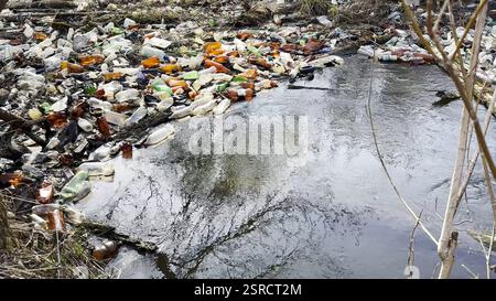 Der schmutzige Fluss ist mit vielen Plastikflaschen verschmutzt. Viel Müll wird an offenen und frei zugänglichen Plätzen in der Natur entsorgt. Globale Umwelt Stockfoto
