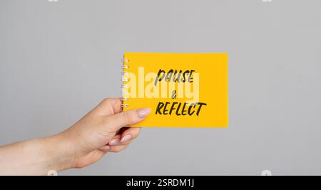 Notizen Pause und Reflexion in einer weiblichen Hand. Halten Sie eine Situation, Erfahrung oder Entscheidung an, denken Sie nach und bewerten Sie sie, bevor Sie fortfahren. Geschäfts- und Zeitmanagement Stockfoto