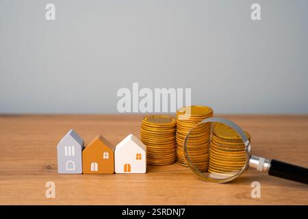 Lupe, Münzen und Haus. Konzept der Haussuche. Hausbewertung. Immobilienbewertung. Wahl des Standorts für die Baustelle. Suchen Sie nach HO Stockfoto