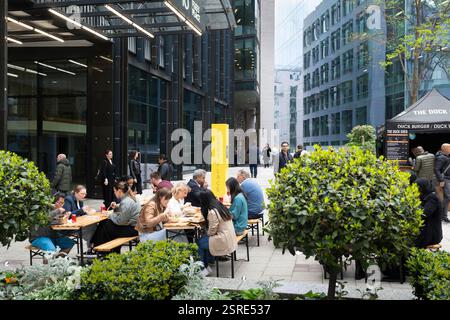 Im Fleet Place speisen die Leute draußen und genießen das Essen aus dem Duck Shed-Imbissstand. Stockfoto