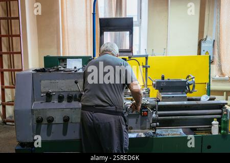 Fabrikarbeiter, der an Drehmaschinen in einer Metallfabrik arbeitet. Stockfoto