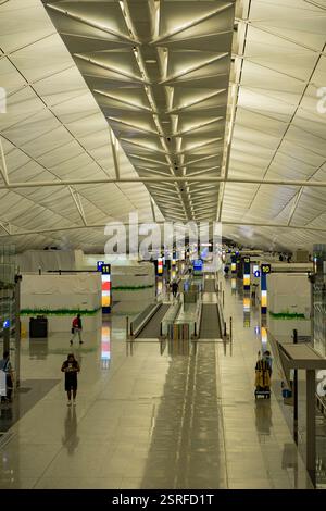 Ein geräumiger Flughafenterminal mit heller Beleuchtung und geometrischem Deckendesign, das während der COVID-19-Konferenz am Flughafen Lai Chi Kok eine ruhige Atmosphäre widerspiegelt. Stockfoto