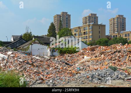 Ziegel- und Schutthaufen aus abgerissenen Häusern in Jiaxing, China, um Platz für modernere Gebäude wie die in der Ferne zu machen. Oktober 2020. Stockfoto