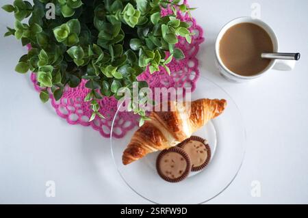 Leckeres Frühstück Croissant, Kekse und eine Tasse Kaffee auf dem Tisch. Stockfoto