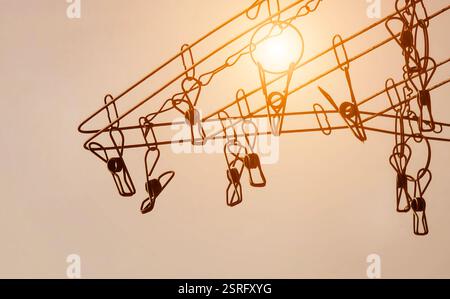 Die Silhouette der farbenfrohen Kleiderschränke hängt an einer Wäscheleine Stockfoto
