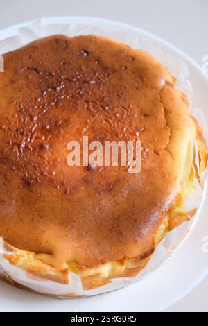 Nahaufnahme von hausgemachtem baskischen Käsekuchen auf einem weißen Teller. Stockfoto