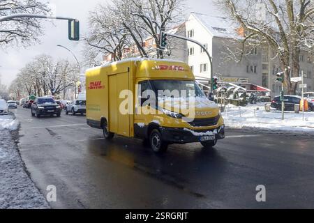 14.02.2025, Berlin, DE - Lieferwagen der DHL mit Elektroantrieb im Winter. Alltag, alternativ, Auslieferungswagen, Aussen, Aussenaufnahme, Batterietechnik, befoerdern, Befoerderung, Berlin, deutsch, Deutschland, DHL, Dienstleistung, E-Auto, E-Lieferwagen, E-Mobilitaet, E-Mobilität, E-Wagen, elektrisch, Elektro LKW, Elektro-LKW, Elektroantrieb, Elektroauto, Elektrobetrieb, Elektrofahrzeug, Elektrolieferwagen, Elektromobil, Elektromobilitaet, emissionsfrei, Europa, europaeisch, Fahrzeug, Gesellschaft, Jahreszeit, Klimaschutz, Laster, Lastkraftwagen, Lieferservice, Lieferung, Lieferwagen, LKW, Stockfoto