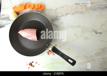 Rohe Schweinefleisch-Steak in einer Pfanne Nahaufnahme. Fleisch kochen. Stockfoto