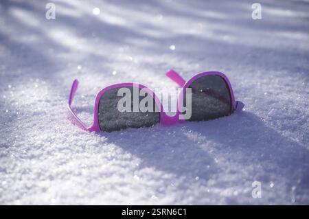 Rosa Sonnenbrille auf dem Schnee Nahaufnahme Stockfoto