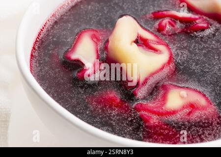 Weihnachtssuppe mit Rote Bete, Borscht mit kleinen Knödeln mit Pilzfüllung Stockfoto