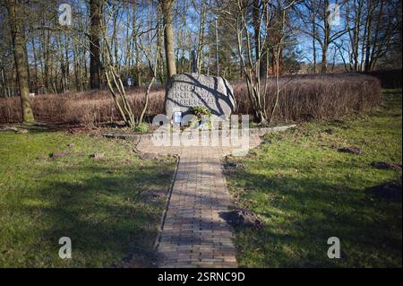 Flensburg, Schleswig-Holstein das Bild zeigt einen Gedenkstein im Carlisle-Park in Flensburg mit der Inschrift den Opfern der Gewaltherrschaft. Vor dem Stein liegen eine Kranzniederlegung mit Tannenzweigen und Zapfen sowie eine blau-gelbe Schleife, die auf die Ukraine hindeuten könnte. Daneben stehen mehrere Grablichter und ein gerahmtes Foto mit einer Gedenkinschrift zu Alexej Nawalny. Die Szenerie ist von Sonnenlicht durchziehen, wobei Baumäste Schatten auf den Stein werfen. Änd. 16. Februar jährt sich der Todestag des russischen Oppositionsführers Alexej Nawalny. Er starb am 16. Februar 2024 i Stockfoto