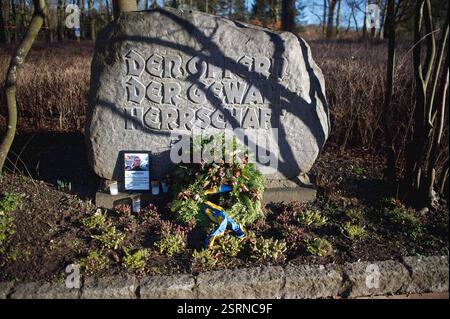 Flensburg, Schleswig-Holstein das Bild zeigt einen Gedenkstein im Carlisle-Park in Flensburg mit der Inschrift den Opfern der Gewaltherrschaft. Vor dem Stein liegen eine Kranzniederlegung mit Tannenzweigen und Zapfen sowie eine blau-gelbe Schleife, die auf die Ukraine hindeuten könnte. Daneben stehen mehrere Grablichter und ein gerahmtes Foto mit einer Gedenkinschrift zu Alexej Nawalny. Die Szenerie ist von Sonnenlicht durchziehen, wobei Baumäste Schatten auf den Stein werfen. Änd. 16. Februar jährt sich der Todestag des russischen Oppositionsführers Alexej Nawalny. Er starb am 16. Februar 2024 i Stockfoto