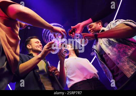 Die Brille in den Händen halten. Gruppe von Freunden, die gemeinsam Spaß im Nachtclub haben. Stockfoto