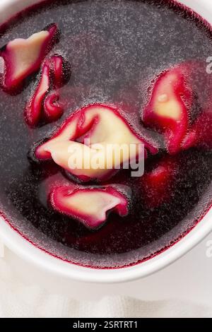 Weihnachtssuppe mit Rote Bete, Borscht mit kleinen Knödeln mit Pilzfüllung Stockfoto