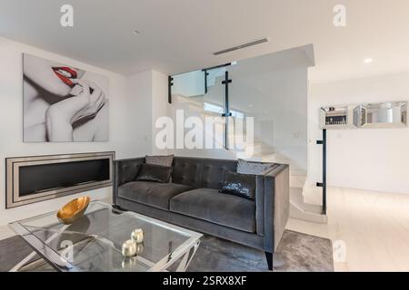 Ein Bild von einem Sitzbereich im Erdgeschoss mit Sofa und Kamin im mediterranen Herrenhaus Stockfoto