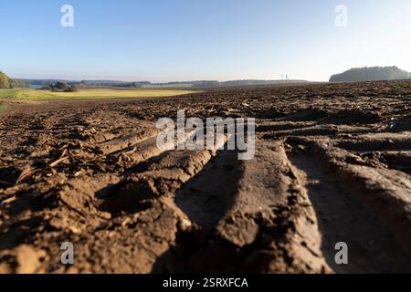Spuren der Lauffläche von Automobilrädern auf dem gepflügten Boden des Feldes, Spuren von Zugmaschinen und anderen landwirtschaftlichen Maschinen auf dem Boden auf dem Feld Stockfoto