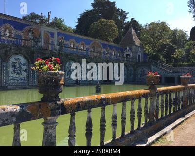 Palais Fronteira Portugal. Farbenfrohe Fliesenwände umranden einen rechteckigen reflektierenden Pool. Üppig grüne Vegetation umrahmt die Szene. Ein Zeugnis für die Reichen Stockfoto