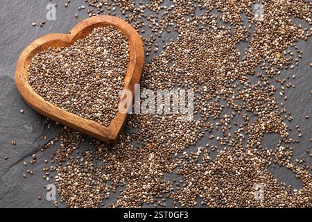 Frische Bio-Chiasamen im herzförmigen Behälter - Salvia hispanica. Stockfoto