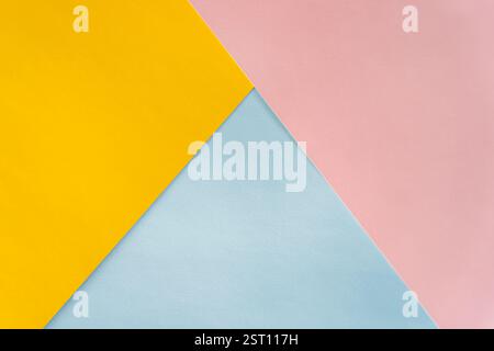 Minimalistischer abstrakter Hintergrund aus überlappendem gelbem, rosa und blauem Papier. Geometrische Komposition ideal für Design, Branding oder kreative Projekte Stockfoto