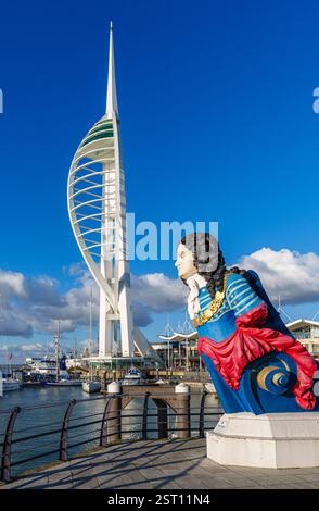 Die farbenfrohe Galionsfigur der HMS Marlborough mit dem Spinnaker Tower in den Gunwharf Quays in Old Portsmouth, Südküste von Hampshire, Großbritannien Stockfoto