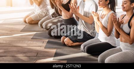 Junger Multiethnischer Yogi, Der Während Des Gruppentrainings Lotusrobben-Geste Macht In Studio Stockfoto