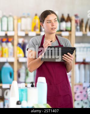 Verkäuferin, die Inventar mit Tablet macht Stockfoto