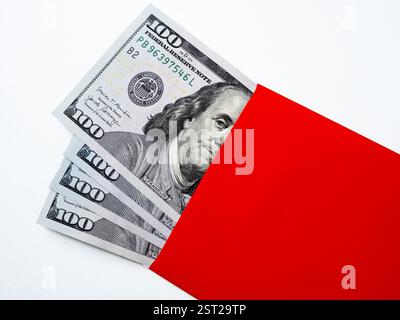 Nahaufnahme 100 Dollar Banknotengeld, Geldfan mit Benjamin Franklins Gesichtsbild in rotem Umschlagpaket, isolierter Hintergrund. Hundert Zahlen Stockfoto