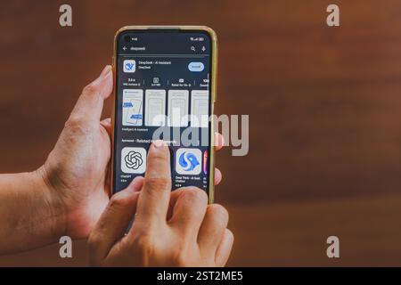 Balikpapan, Indonesien - 16. Februar 2025. Die Hände einer Person, die ein Mobiltelefon hält. Auf dem Bildschirm wird die App-Liste für DeepSeek AI Assistant angezeigt. Stockfoto