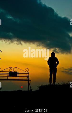 Ein einsamer Mann, der auf Grün sitzt Stockfoto