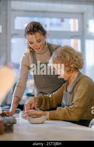 Kaukasische Frauen arbeiteten in der Keramikwerkstatt zusammen mit Lehm Stockfoto