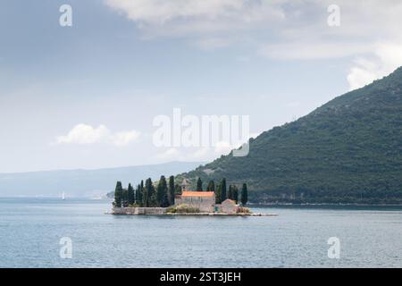 Ein ruhiger Blick auf eine Insel mit einer historischen Kirche inmitten ruhiger Bucht, umgeben von üppigem Grün. Die natürliche Landschaft weckt Ruhe und Ruhe Stockfoto