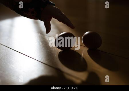 Das Kind nimmt ein Ei vom Boden Stockfoto