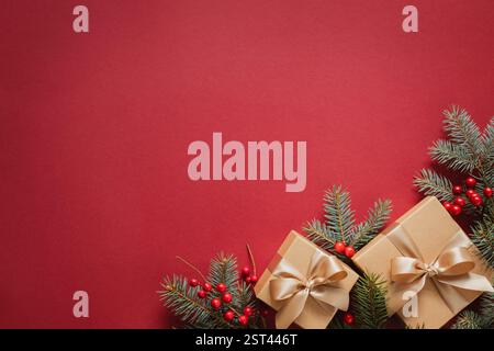 Neujahrskarte mit Weihnachtsgeschenkboxen mit Tannenbrunches auf rotem Hintergrund. Stockfoto