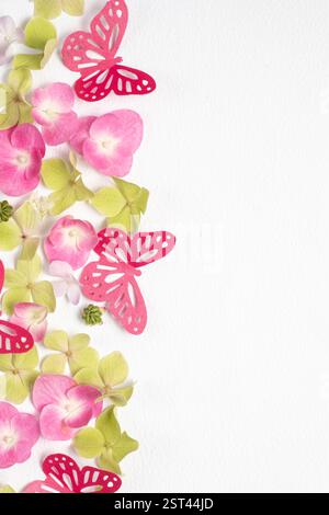 Zarte romantische Komposition flache Lage von Papierschmetterlingen und Blumenhortensie auf weißem Hintergrund. Papierkunst Stockfoto