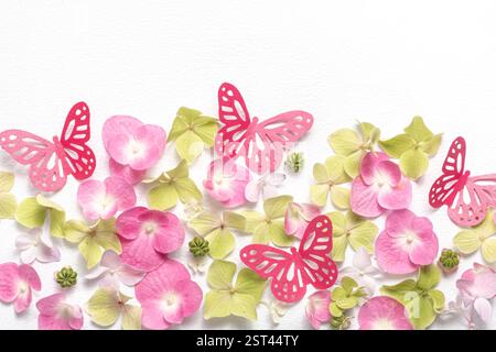 Zarte romantische Komposition flache Lage von Papierschmetterlingen und Blumenhortensie auf weißem Hintergrund. Papierkunst Stockfoto