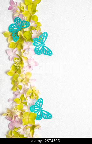 Zarte romantische Komposition flache Lage von blauen Papierschmetterlingen und Blumenhortensie auf weißem Hintergrund. Papierkunst Stockfoto