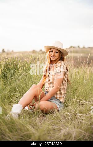 Eine stilvolle junge Frau auf einem grasbewachsenen Feld Stockfoto